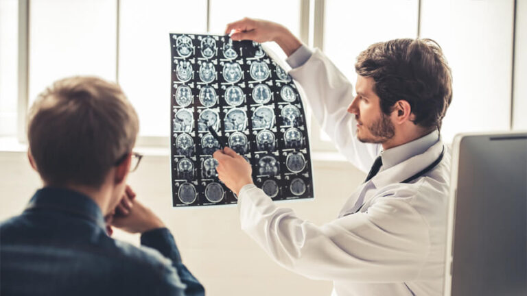 Neurologe zeigt einem Patienten eine Röntgenaufnahme